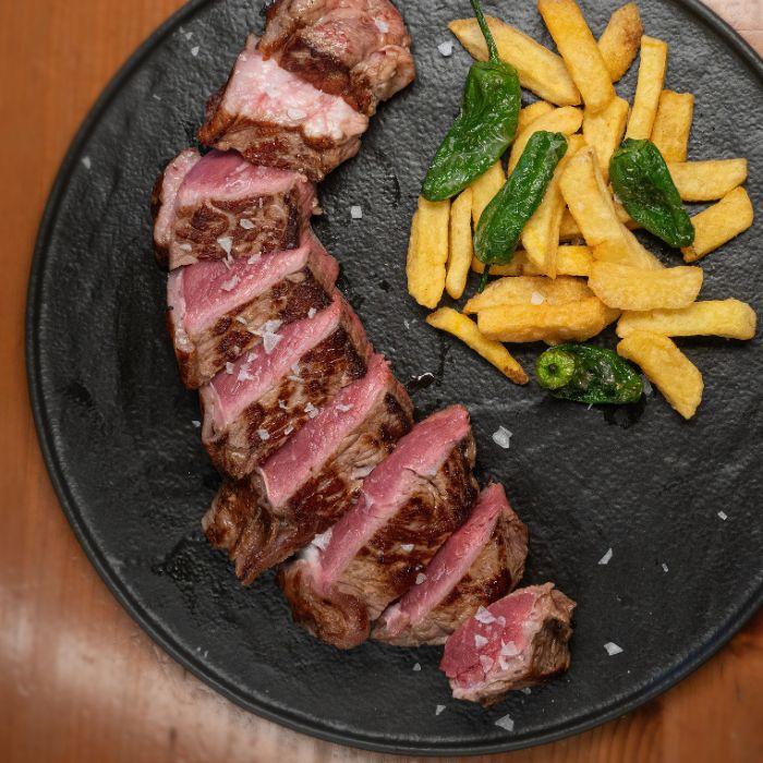 Entrecot a la brasa con patatas fritas y pimientos de Padrón en La Auténtica Carmela, Granada