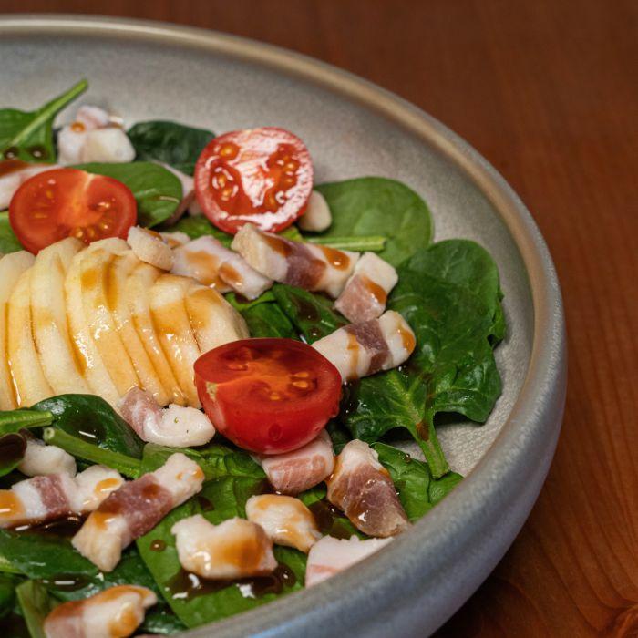 Ensalada de espinacas con manzana, tomate cherry y jamón ibérico en La Auténtica Carmela