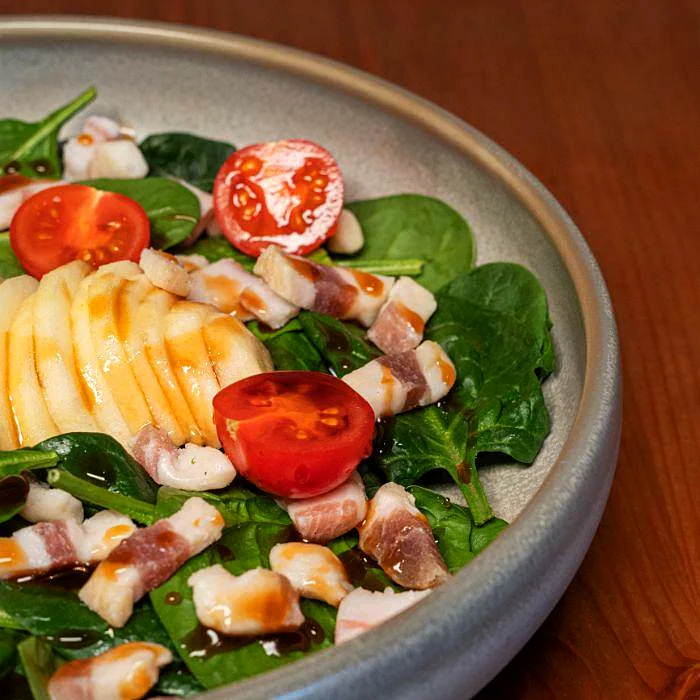 Ensalada de espinacas con manzana, tomate cherry y jamón ibérico en La Auténtica Carmela