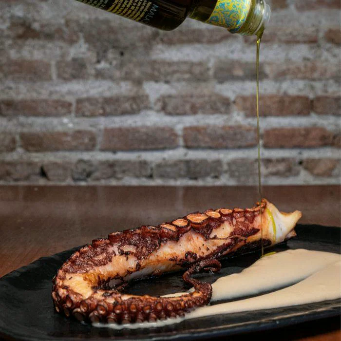 Pulpo a la brasa con aceite de oliva virgen extra en La Auténtica Carmela