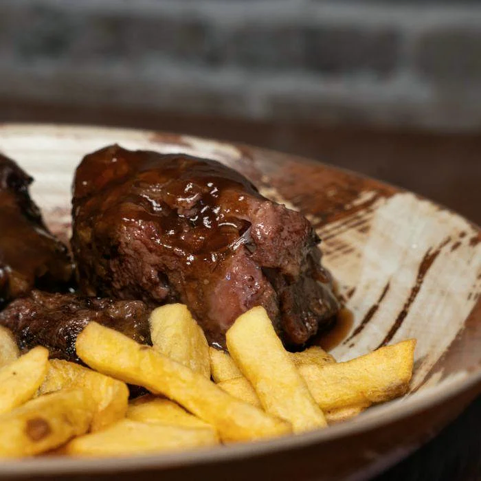 Rabo de toro guisado con patatas fritas en La Auténtica Carmela