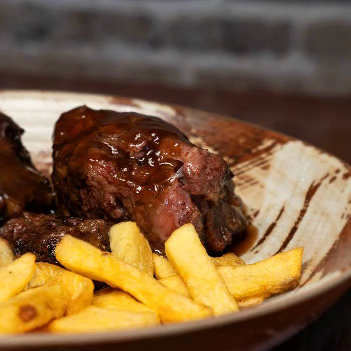 Rabo de toro guisado con patatas fritas en La Auténtica Carmela